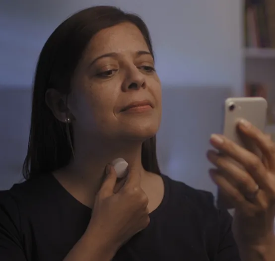 Woman applying AcuPebble SA100 sleep sensor